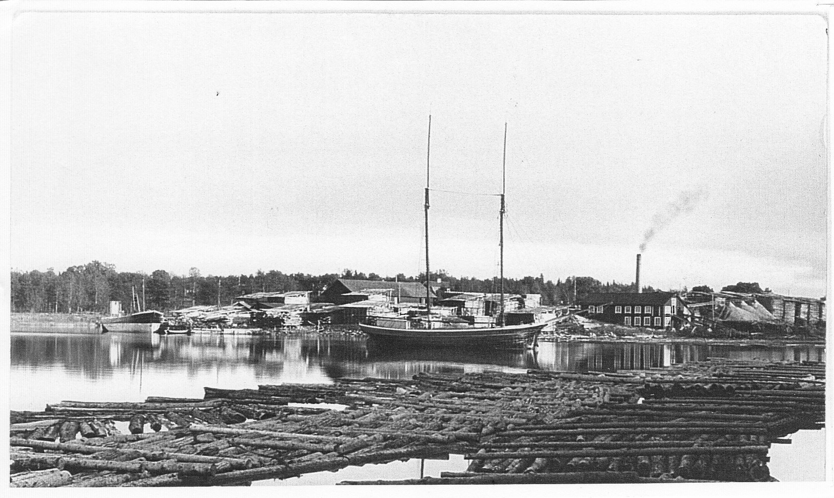 Bogserbåten "Emil" som tillhörde Elmsta Ångsåg. Vid sågens brygga ligger skutan "Sari". 